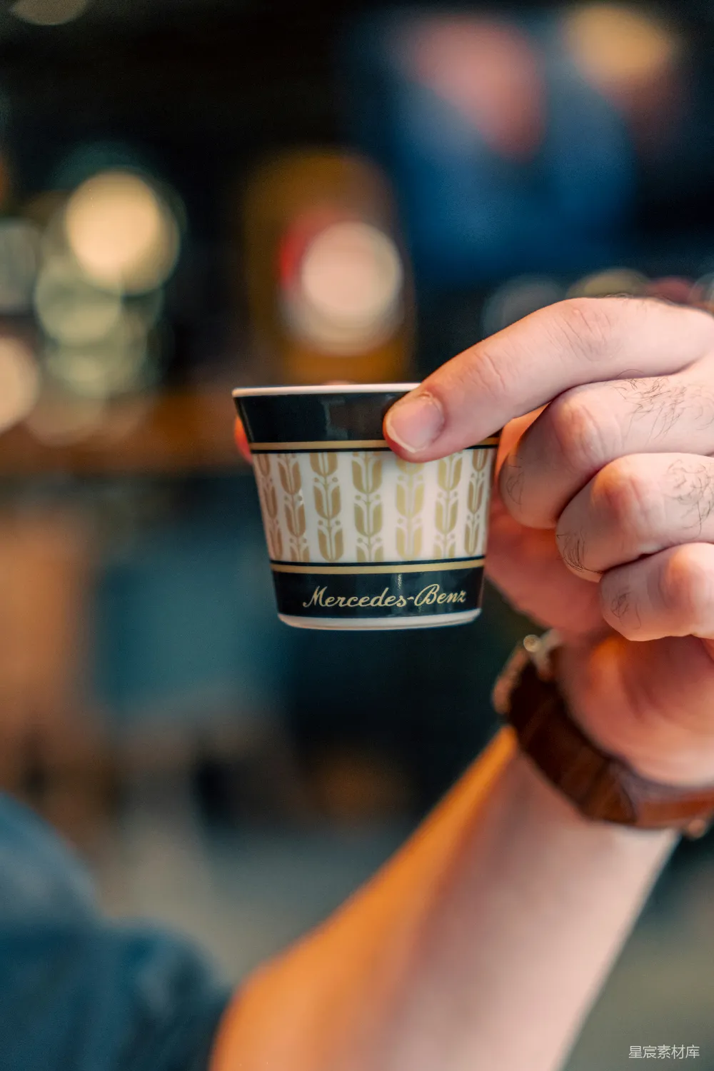 高清摄影 手持带有梅赛德斯-奔驰标志的小杯