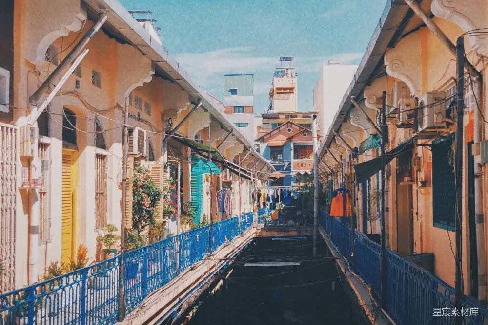 高清摄影 一条狭窄的街道，两侧是建筑，有蓝色的栏杆。