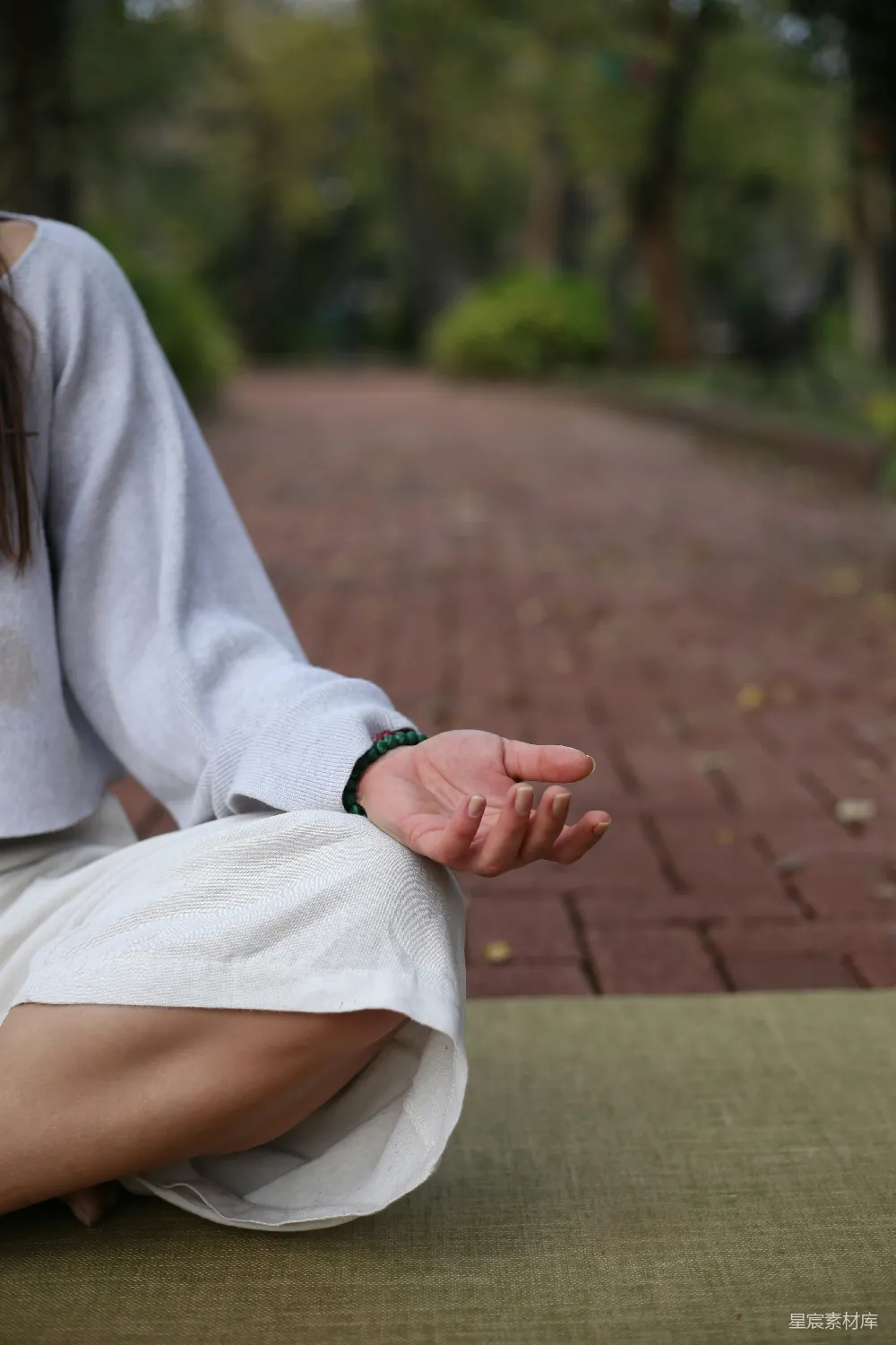 高清摄影  一个女人坐在垫子上莲花坐姿。