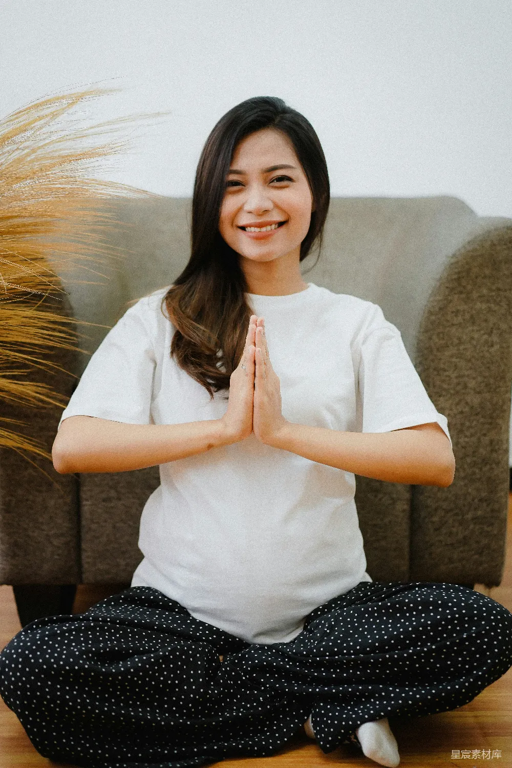 高清摄影  白衬衫和黑白条纹裤的女子坐在棕色的沙发上，身穿白色上衣。