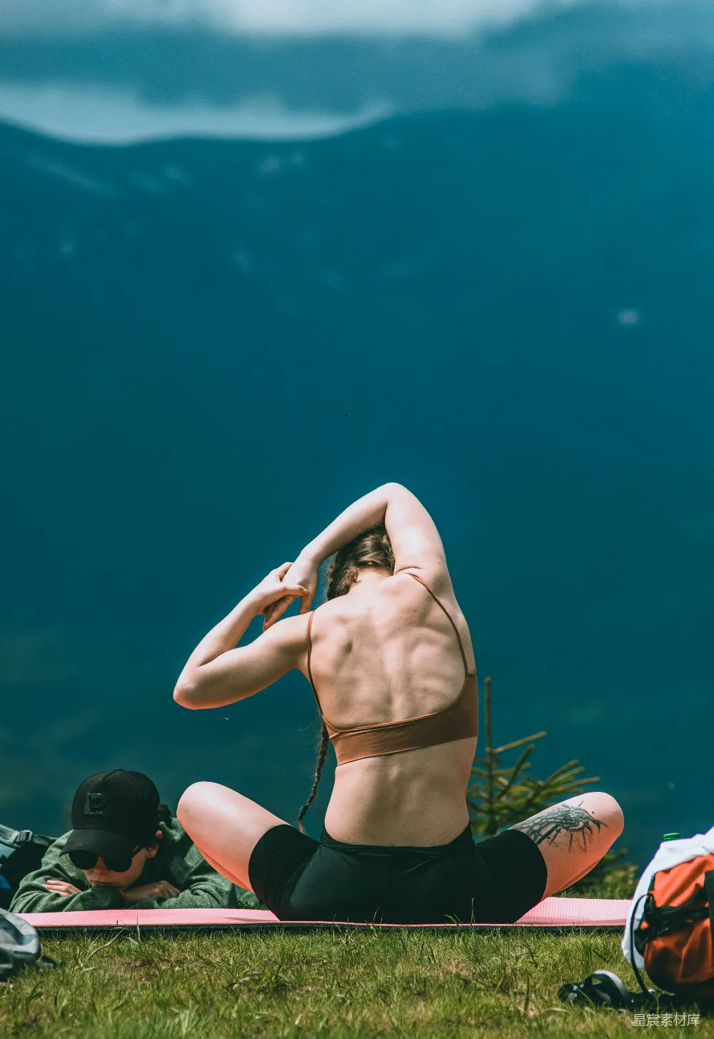 高清摄影 一个男人坐在草地上的一块冲浪板上