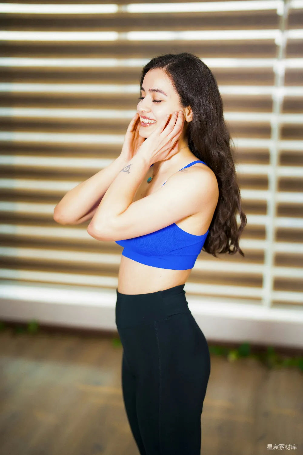 高清摄影 一位妇女站在窗前，双手捂住脸。