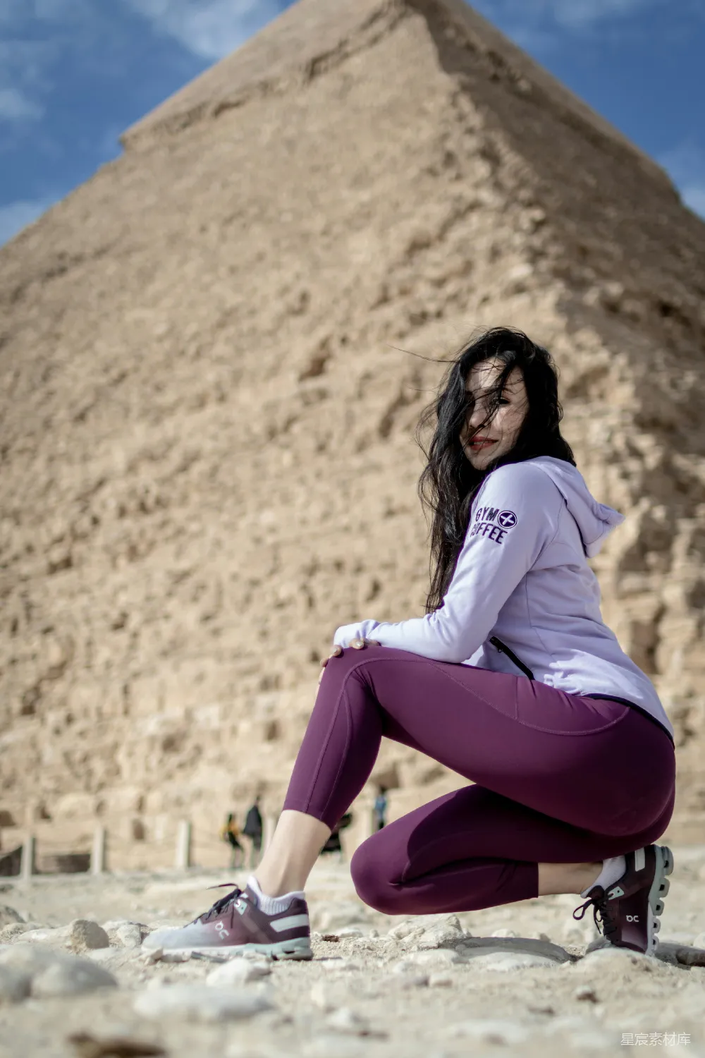 高清摄影 人物 地上坐着一位妇女，她面前是一座金字塔。