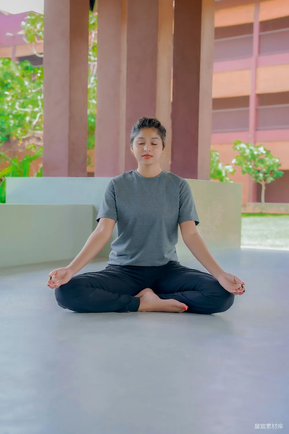 高清摄影 一个男人坐在莲花坐姿前的一栋建筑前
