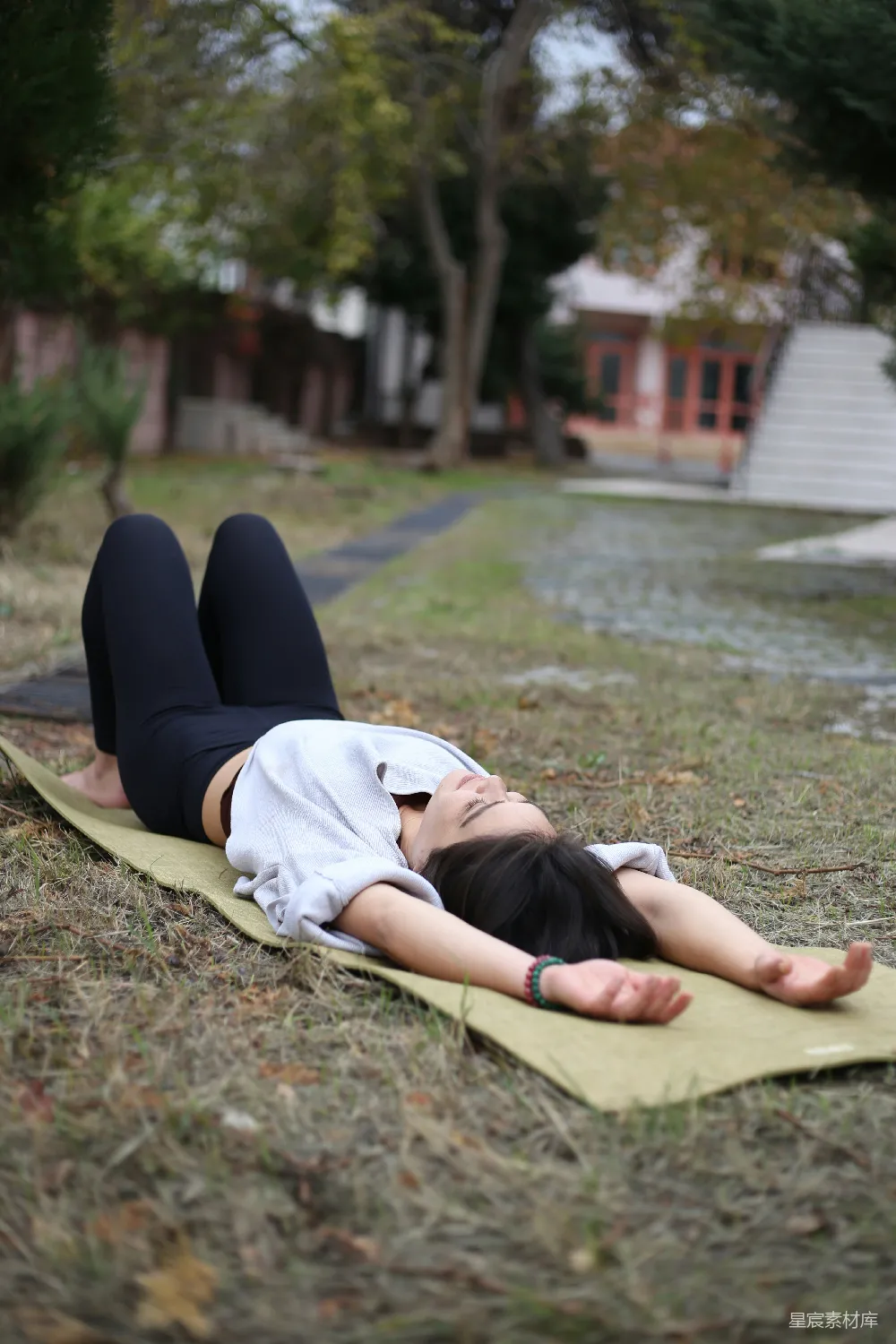 高清摄影 公园里一名女子躺在瑜伽垫上