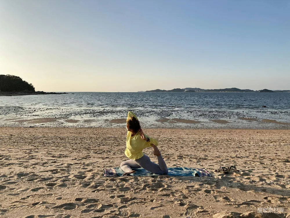 高清摄影 黄色连衣裙的女人坐在海边沙滩上，白天时光。