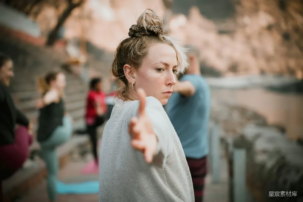 高清摄影  一个妇女指着某物，其他人则在一旁观看。
