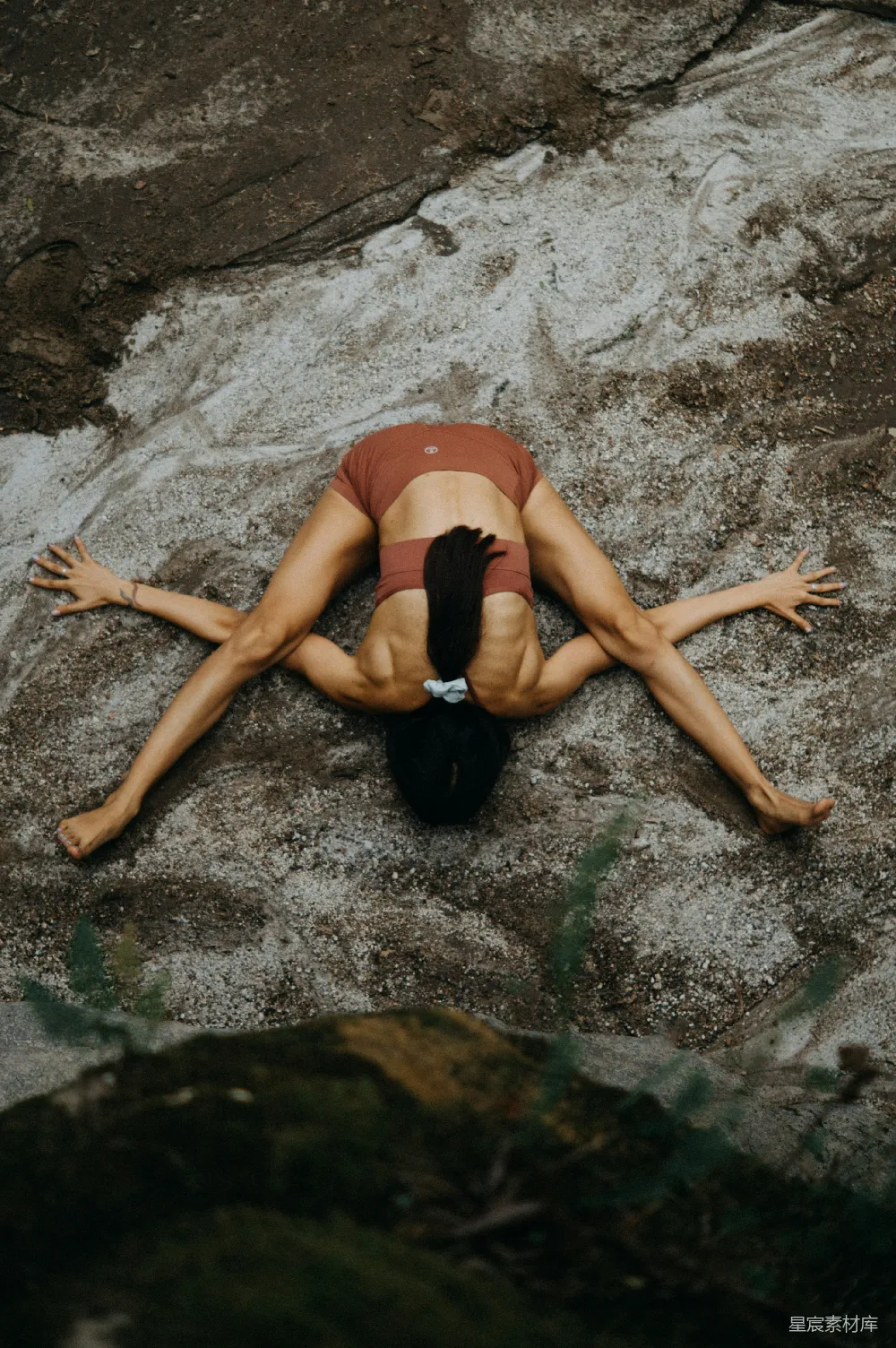 高清摄影 一个女人躺在一块岩石上，旁边是一条河。