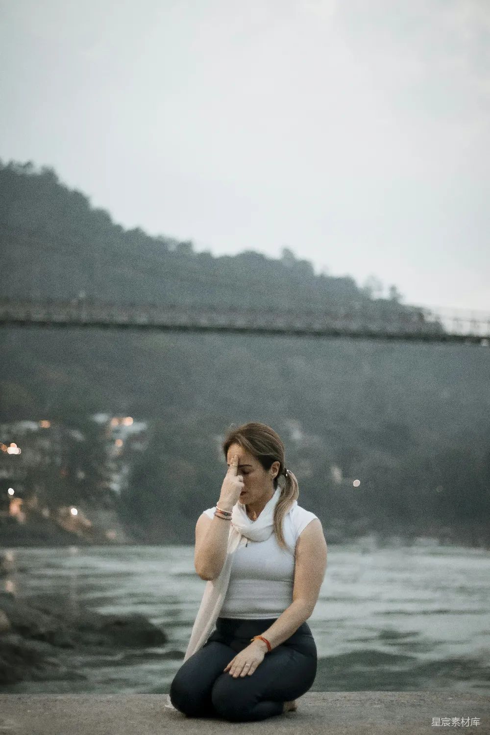 高清摄影 壁纸 地上坐着一位妇女，面前是一条河。