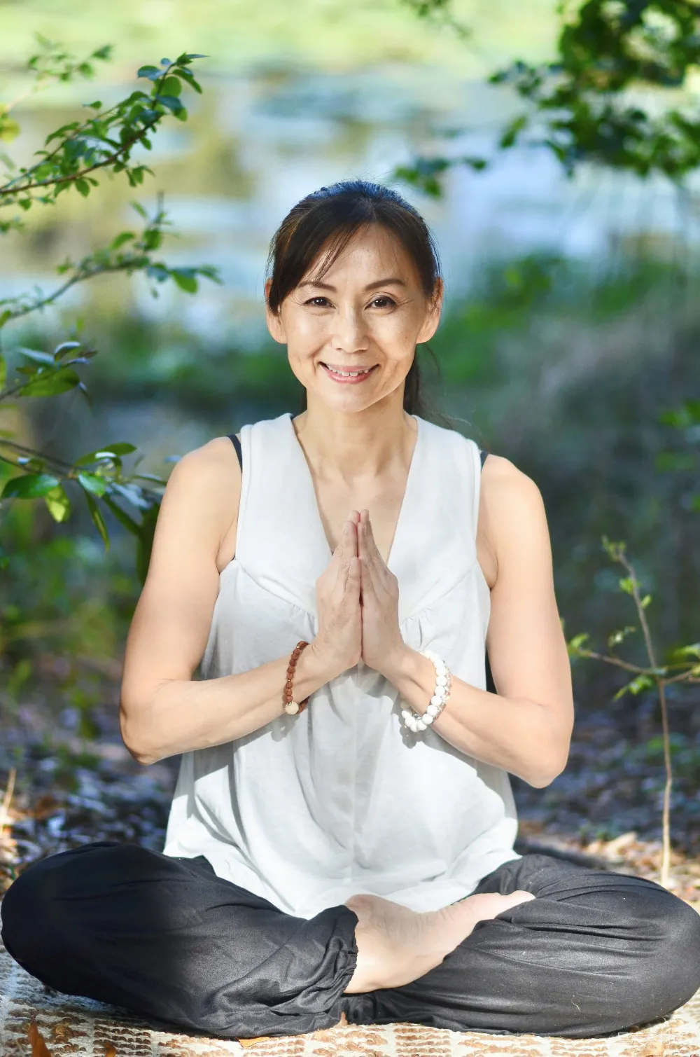 高清摄影  一个穿着白色上衣和黑色裤子的女人坐在瑜伽姿势中