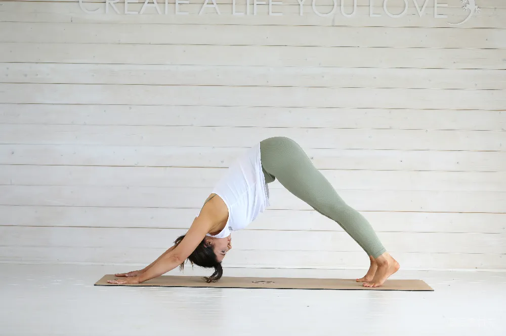 高清摄影 女性在瑜伽垫上的 downward dog 姿势。