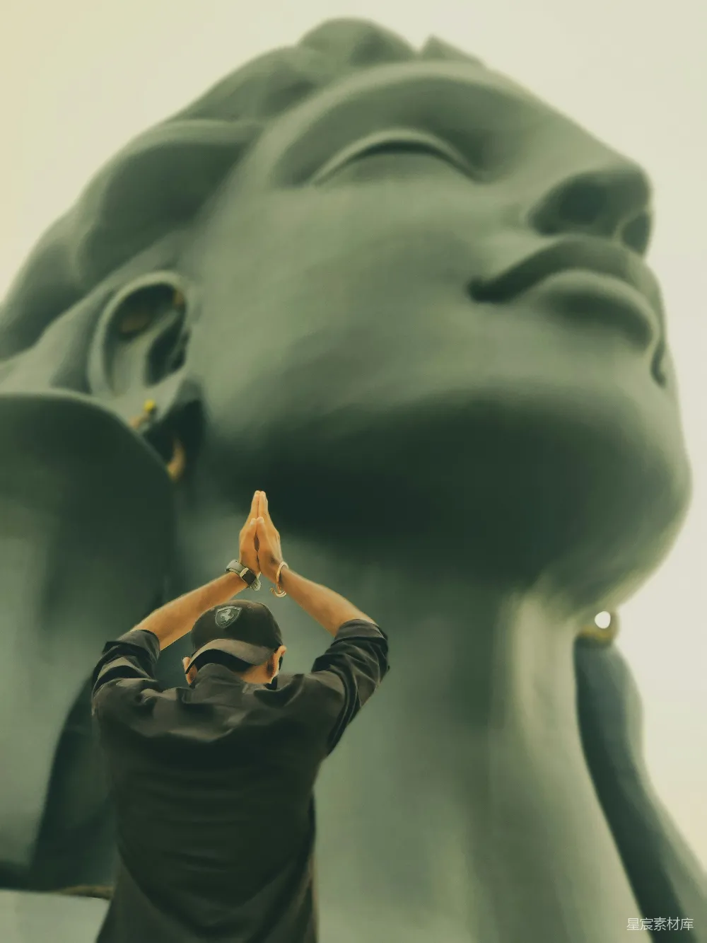 高清摄影 一个男人站在一座大雕像面前。