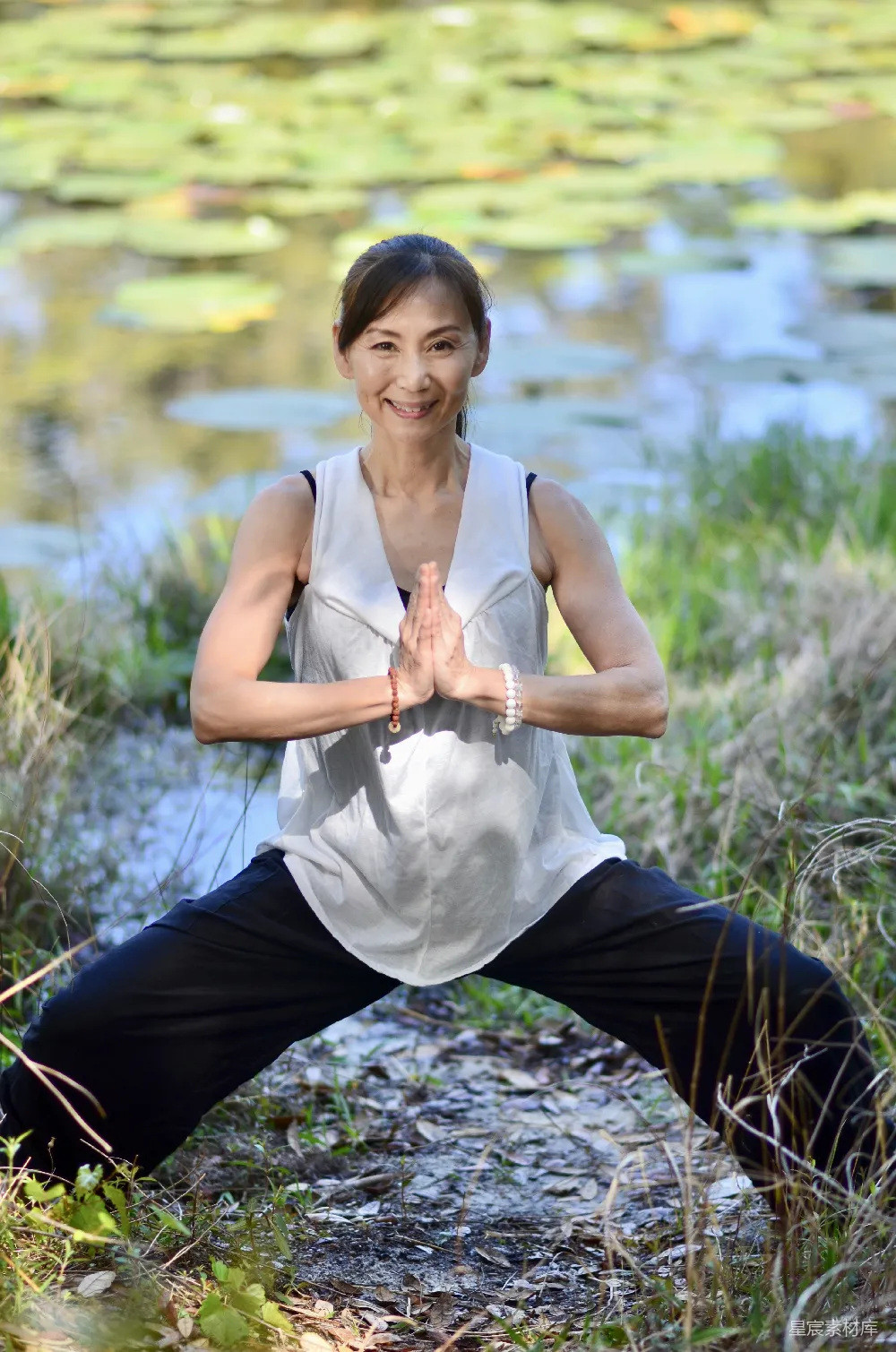 高清摄影 一个女人在水边做瑜伽。