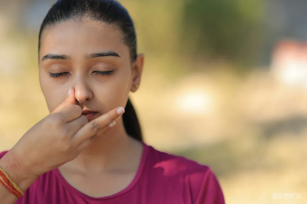 高清摄影 年轻女子在户外练习交替鼻孔呼吸。