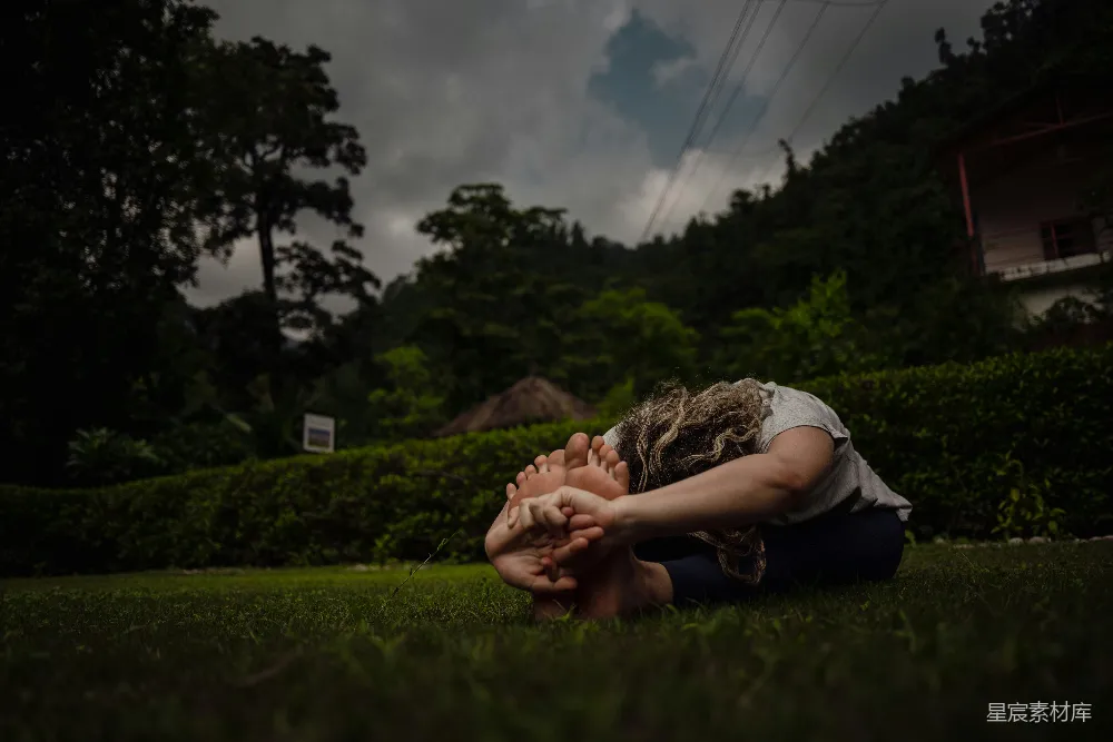 高清摄影 一个女人坐在草地上，用手捂住脸。