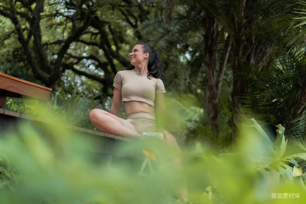 高清摄影 一位妇女在绿树成荫的户外进行冥想。