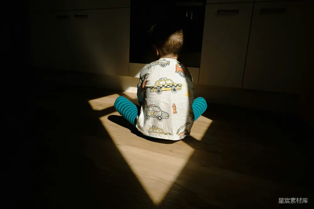 高清摄影 一个幼童坐在厨房的地板上。