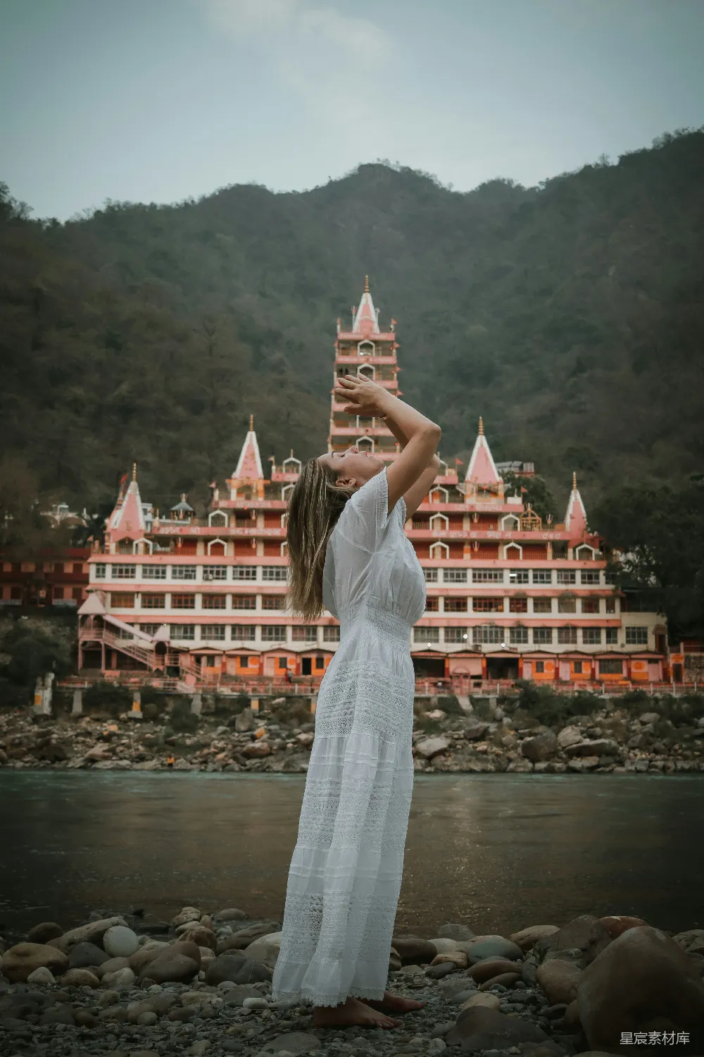 高清摄影 一个穿着白裙子的女人站在一座大建筑物前