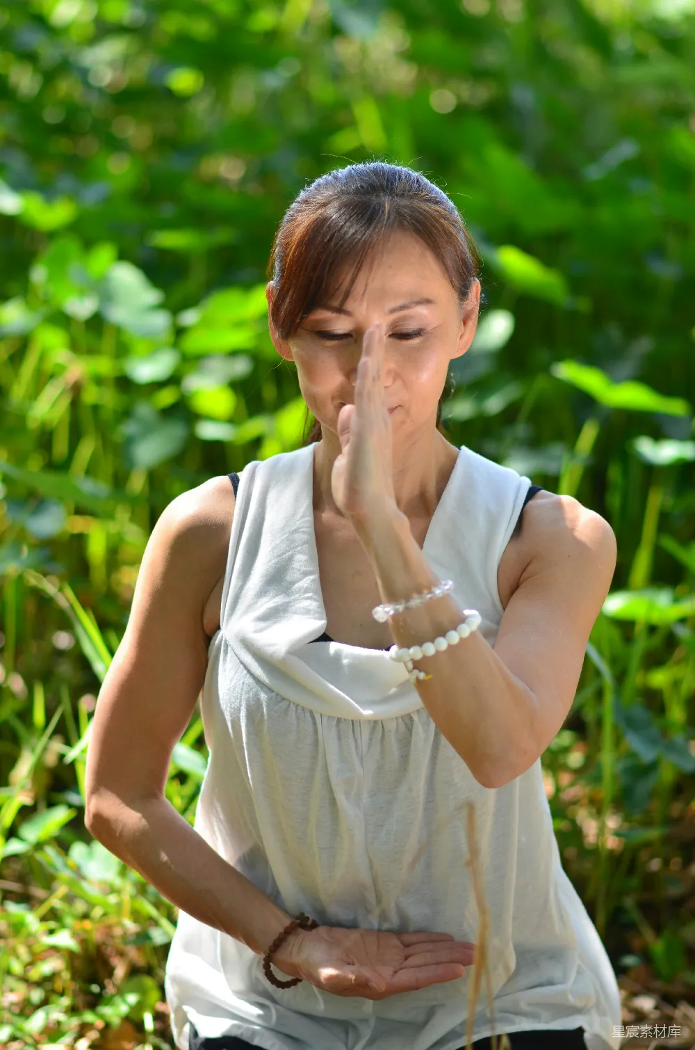 高清摄影 一个女子站在一片草地上擤鼻涕。