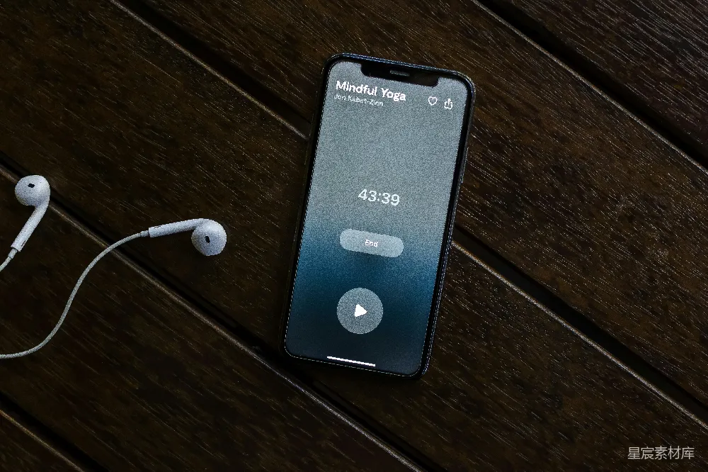 高清摄影  木桌上的一个iPhone和一对耳机