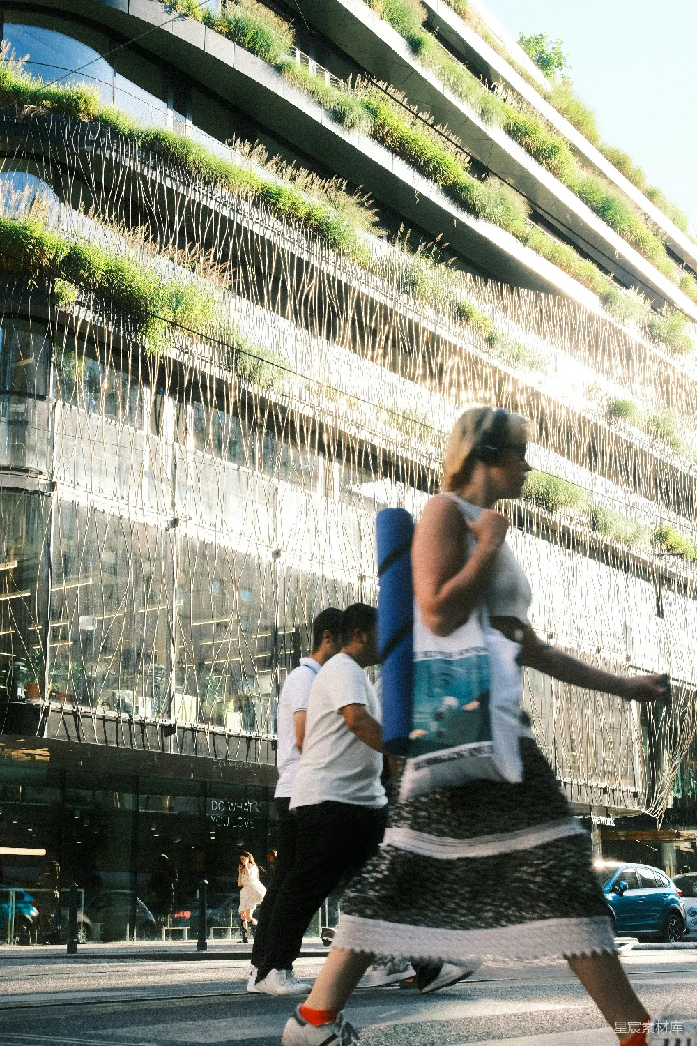 高清摄影 妇女在一座现代建筑前横穿街道