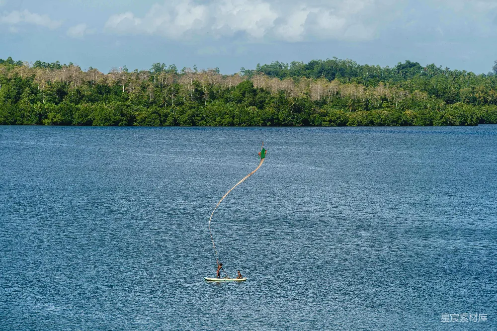 高清摄影 一个人在湖上 parasailing，背景是树木。