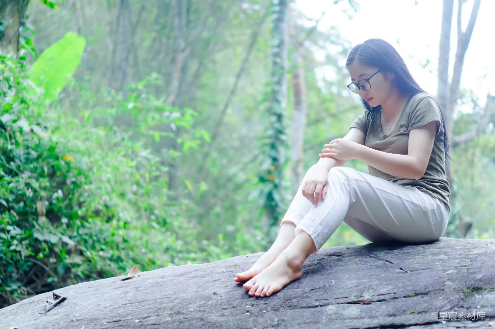 高清摄影 woods中的一块岩石上坐着一位妇女