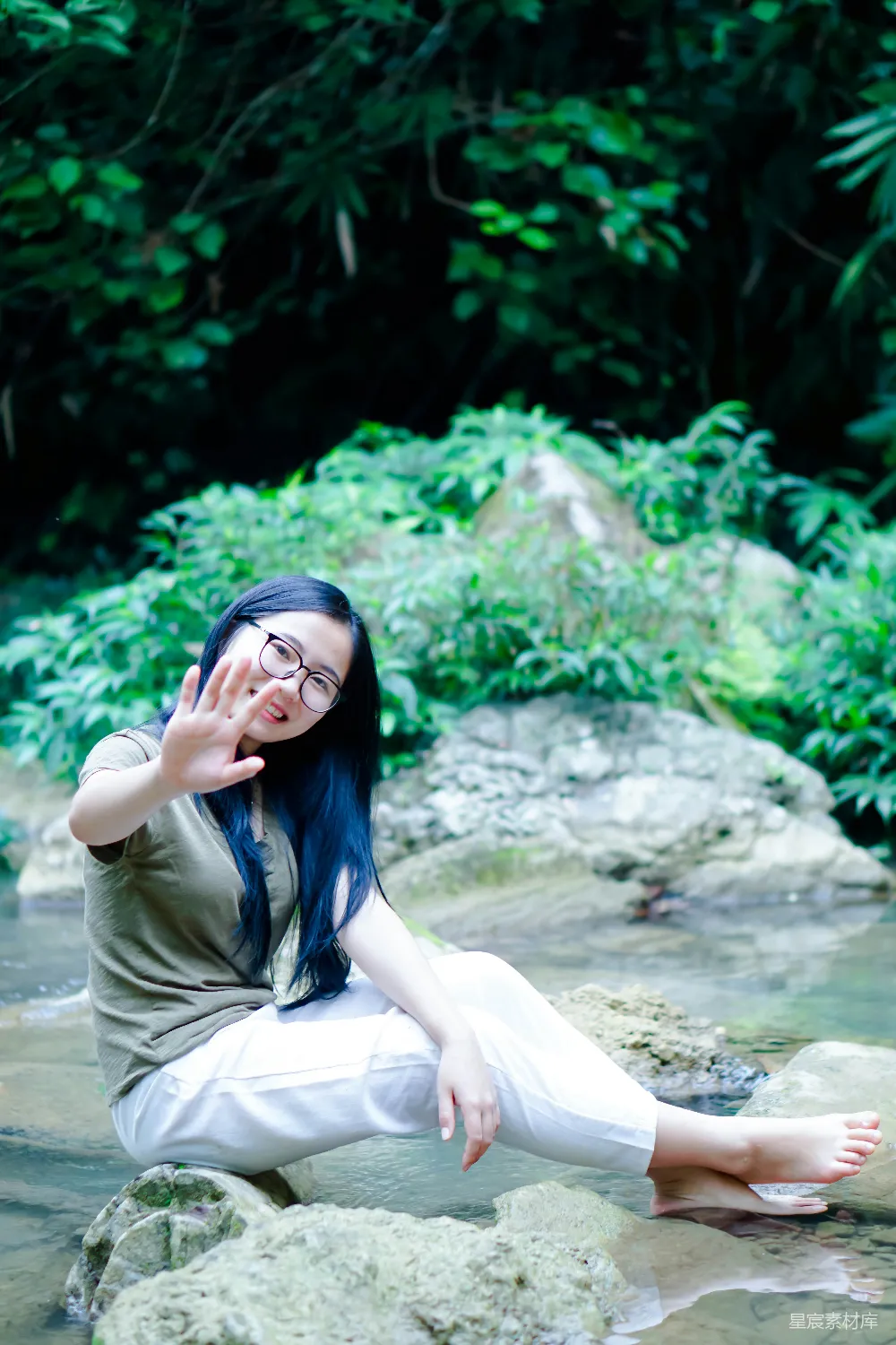 高清摄影 一个女人坐在水边的岩石上