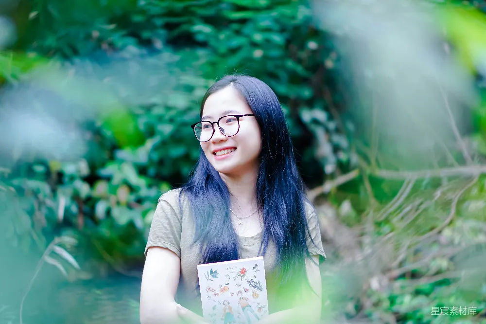高清摄影  一个蓝发戴着眼镜的女人手持一本书