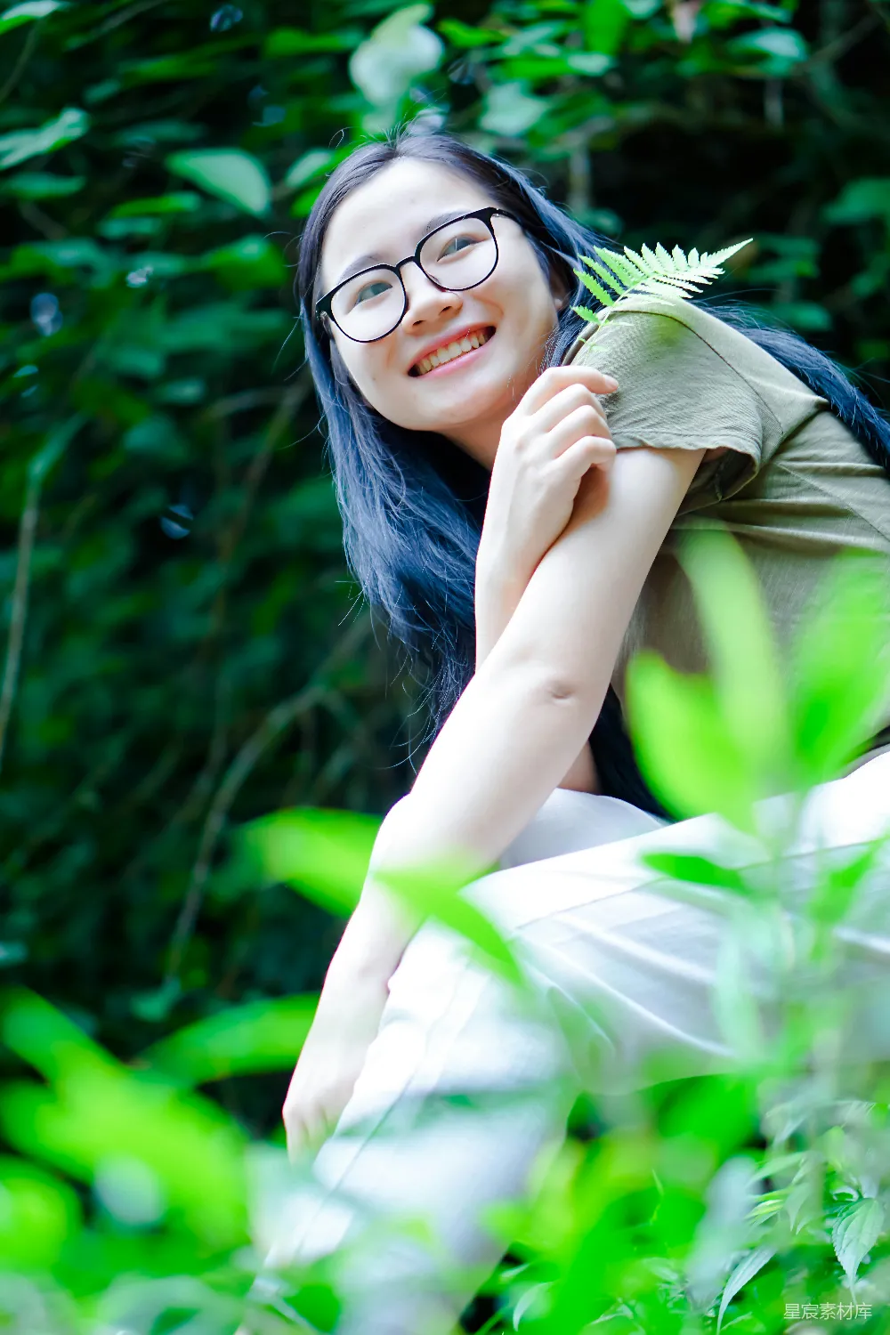 高清摄影  戴眼镜的女士正拿着一盆植物。