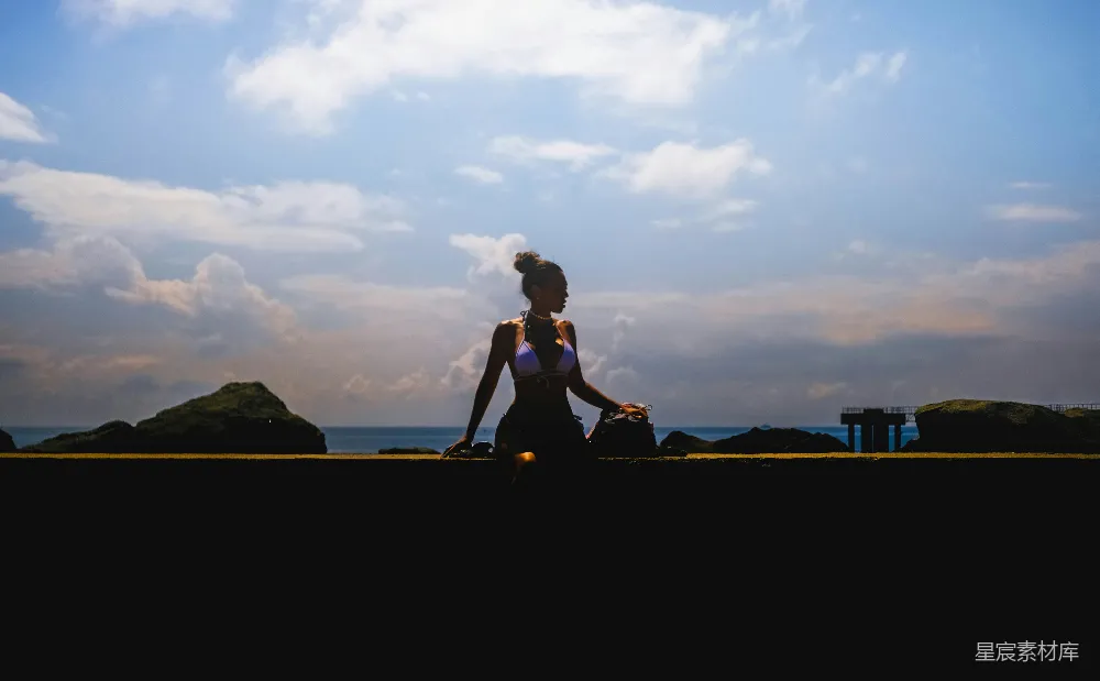 高清摄影 黑色连衣裙上衣和黑色长裤的女人在棕色木制围栏旁坐在日落时分。