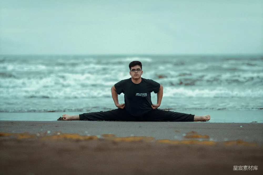 高清摄影 一个男人坐在海滩上的瑜伽姿势中