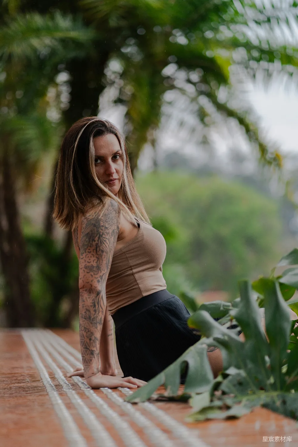 高清摄影 有纹身的女人坐在户外靠近植物的地方