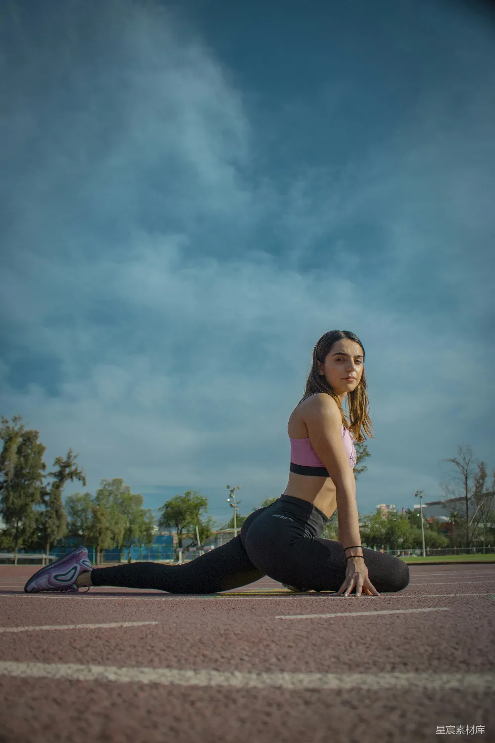 高清摄影 黑T恤女子坐在棕色木凳上，穿着黑色紧身 leggings，在白天。