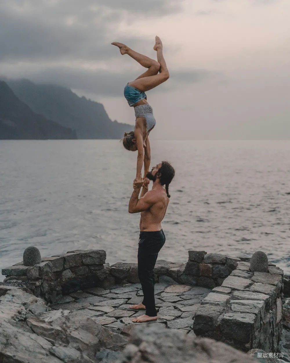 高清摄影 一个男人倒立，背后有一个女人。
