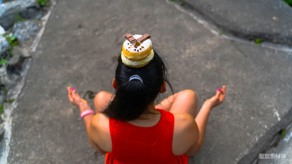 高清摄影 一个穿红色连衣裙的女子坐在一块岩石上。