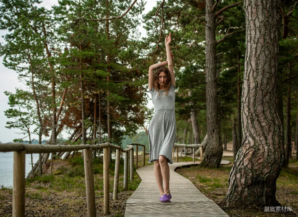 高清摄影 灰衣女子在森林里的木板小径上行走。