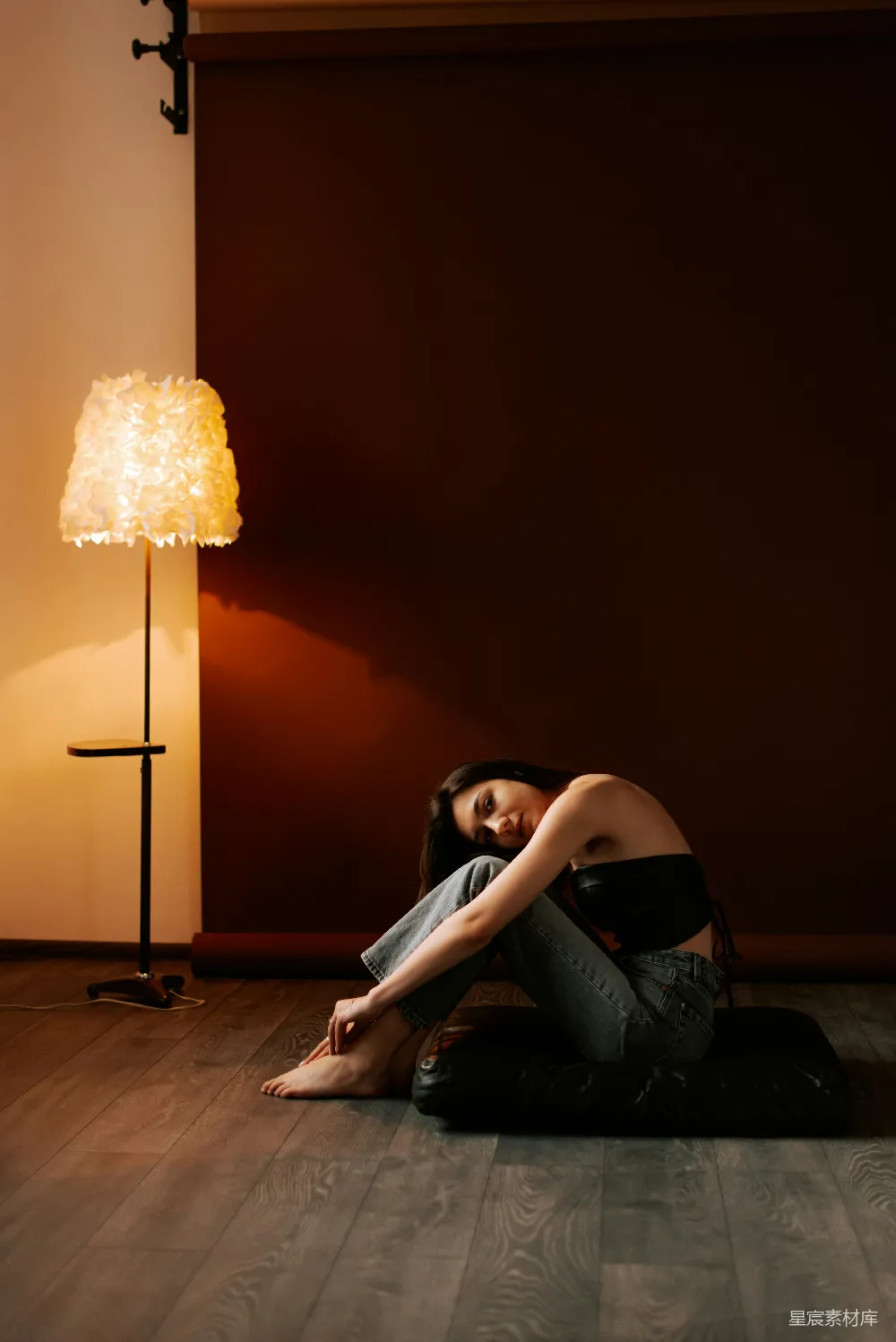 高清摄影 一个女人坐在地上，旁边有一盏灯。