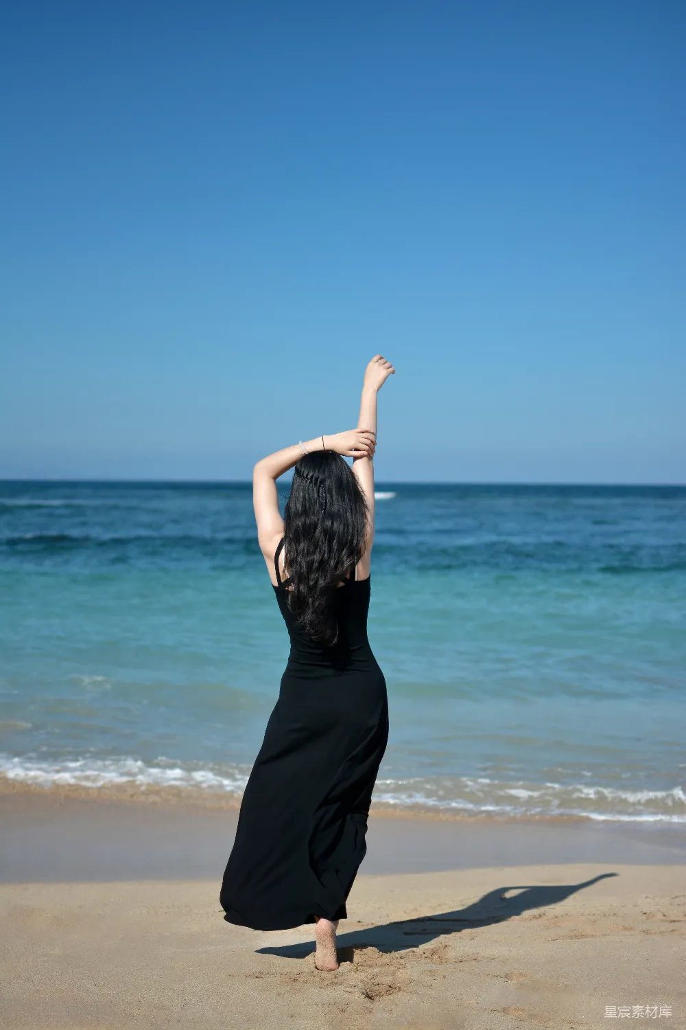 高清摄影  海滩上的女子拥抱阳光。