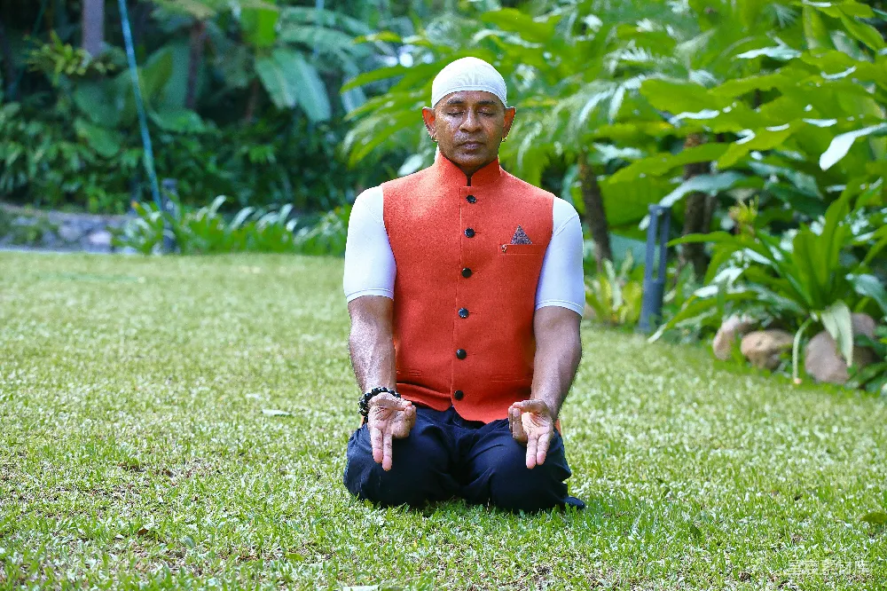 高清摄影 一个穿红背心的男人坐在草地上。
