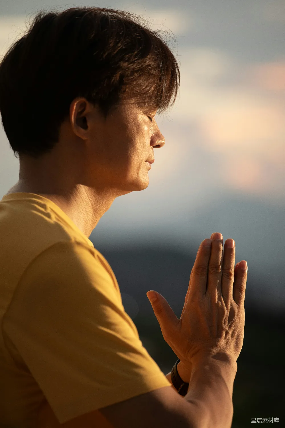 高清摄影 户外静坐者双手合十于日落时分。