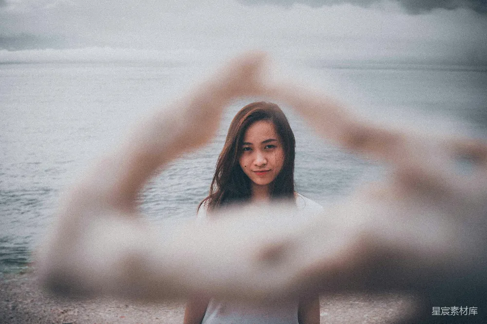 高清摄影 白上衣女子站在海滩上，白天站立。