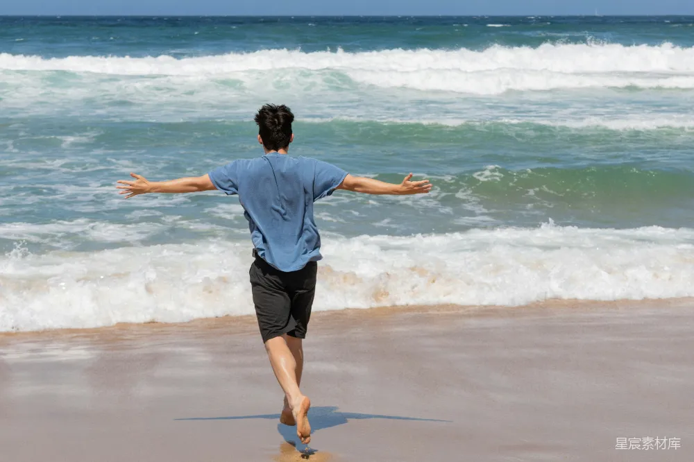 高清摄影 人们欢快地用敞开的双臂拥抱海浪。