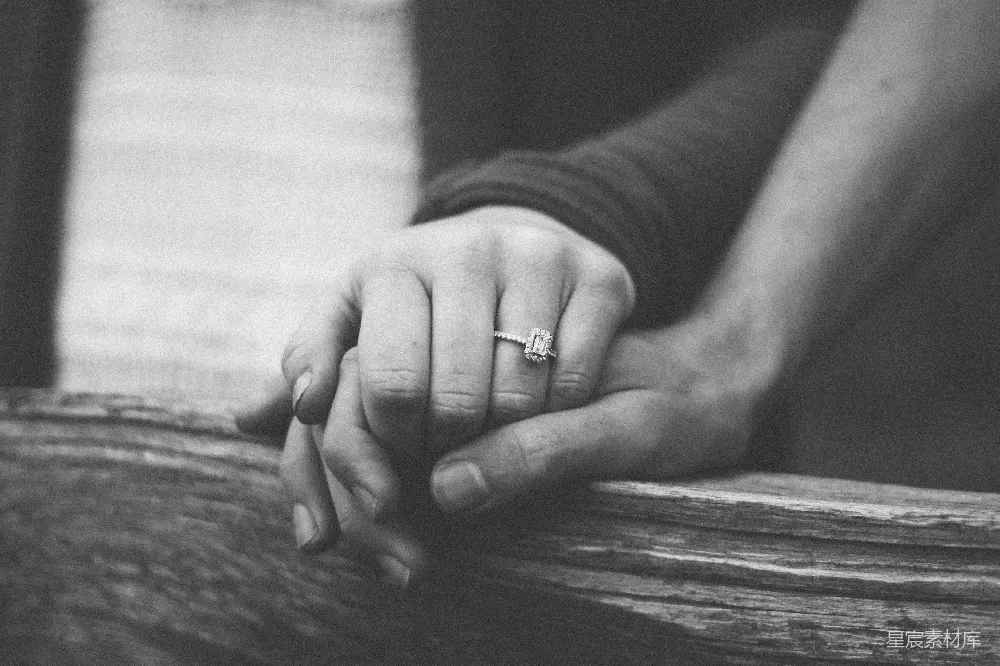 高清摄影  一对人手牵手，佩戴着一枚婚戒。