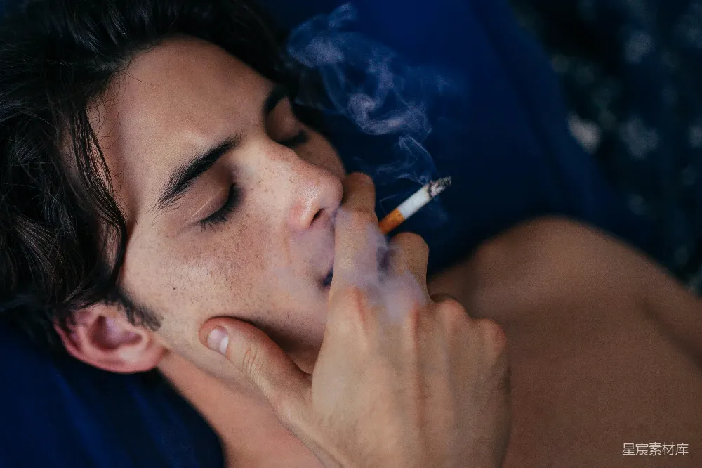 高清摄影  一个男人躺在床上抽烟。