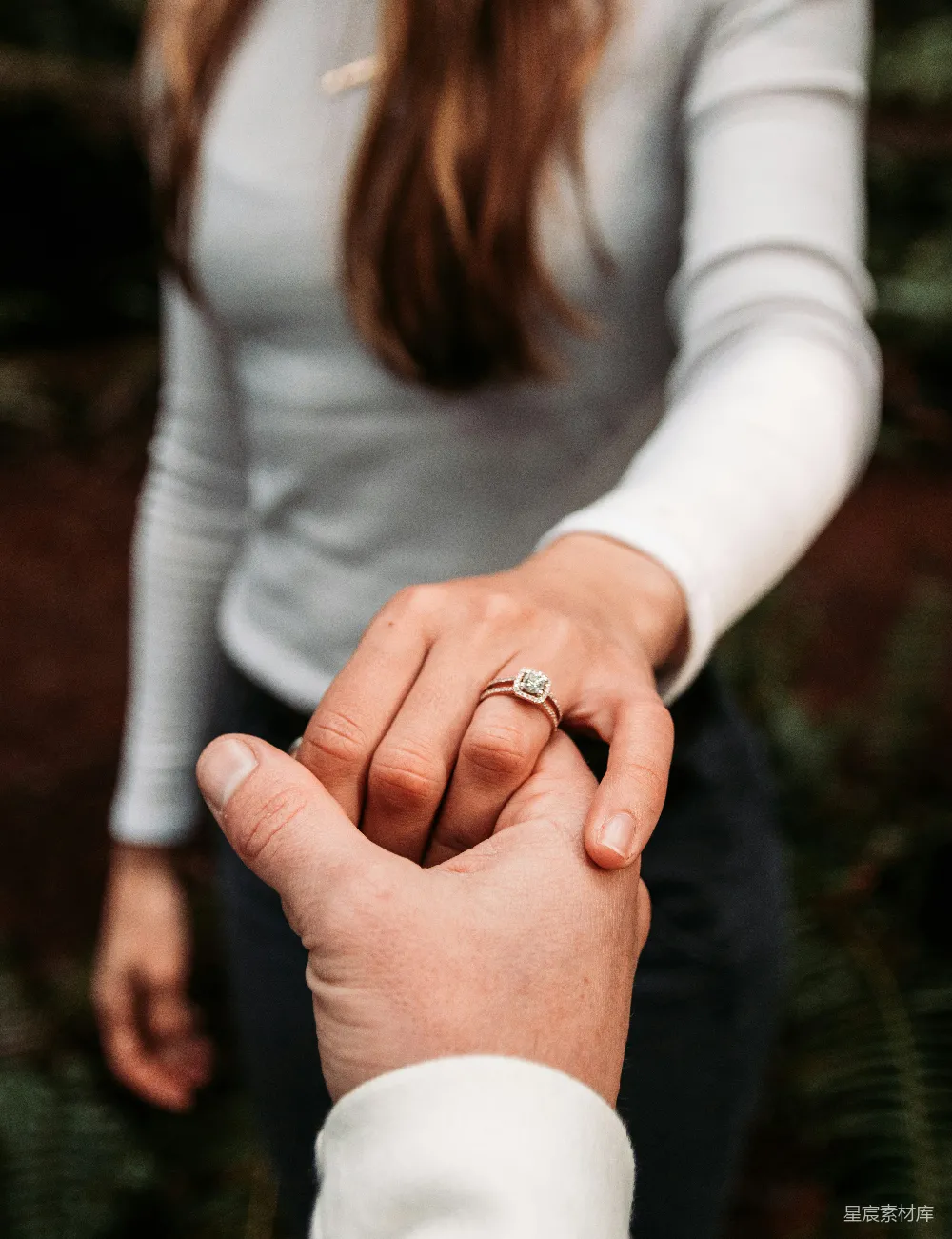 高清摄影 戴着戒指的女人正牵着一个男人的手。
