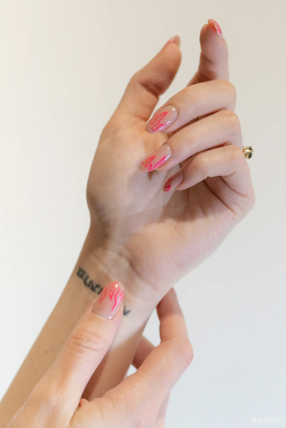 高清摄影 一个女子的手，带着粉色和白色的 manicure。
