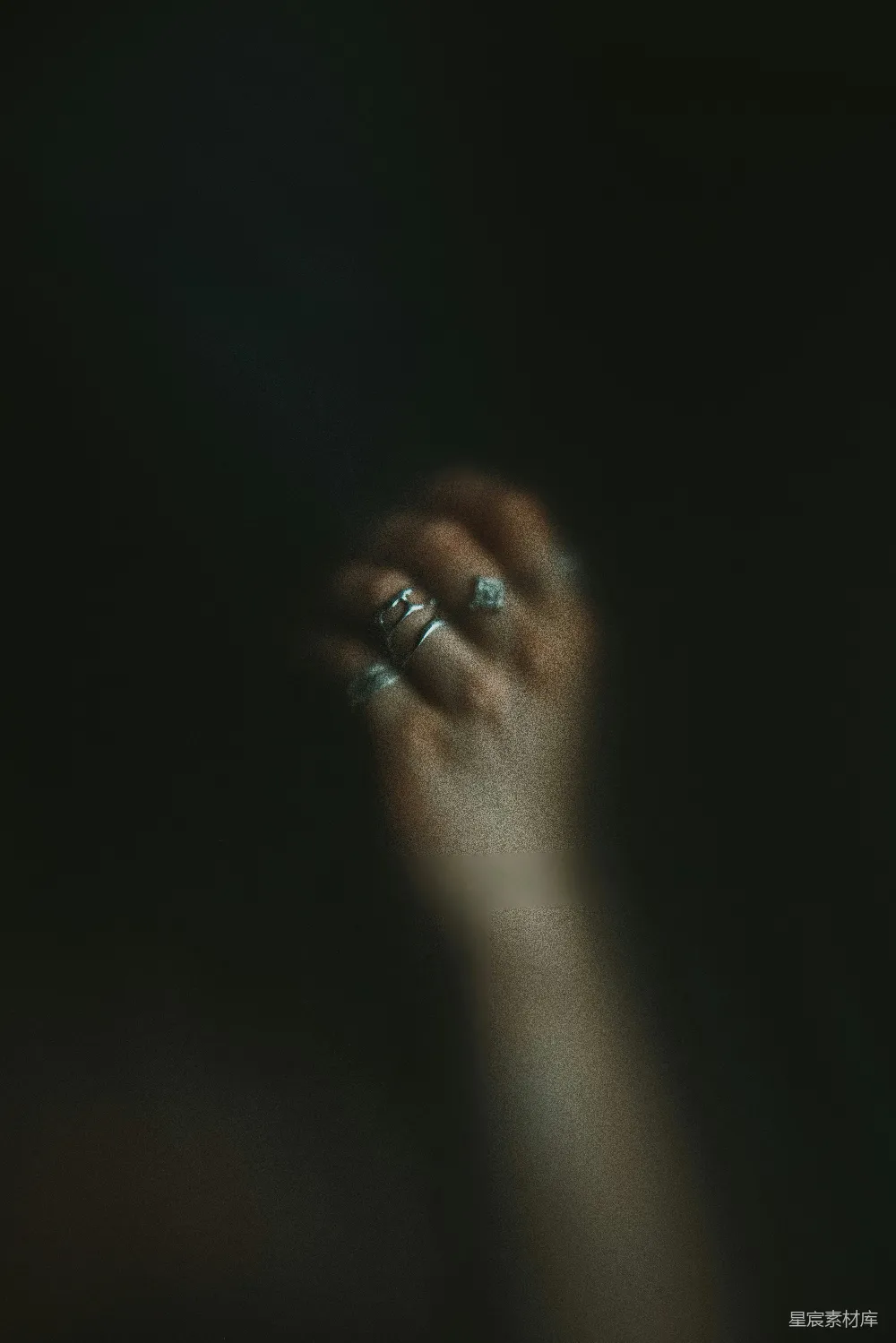高清摄影 一个女人的手拿着一枚戒指，在黑暗中。