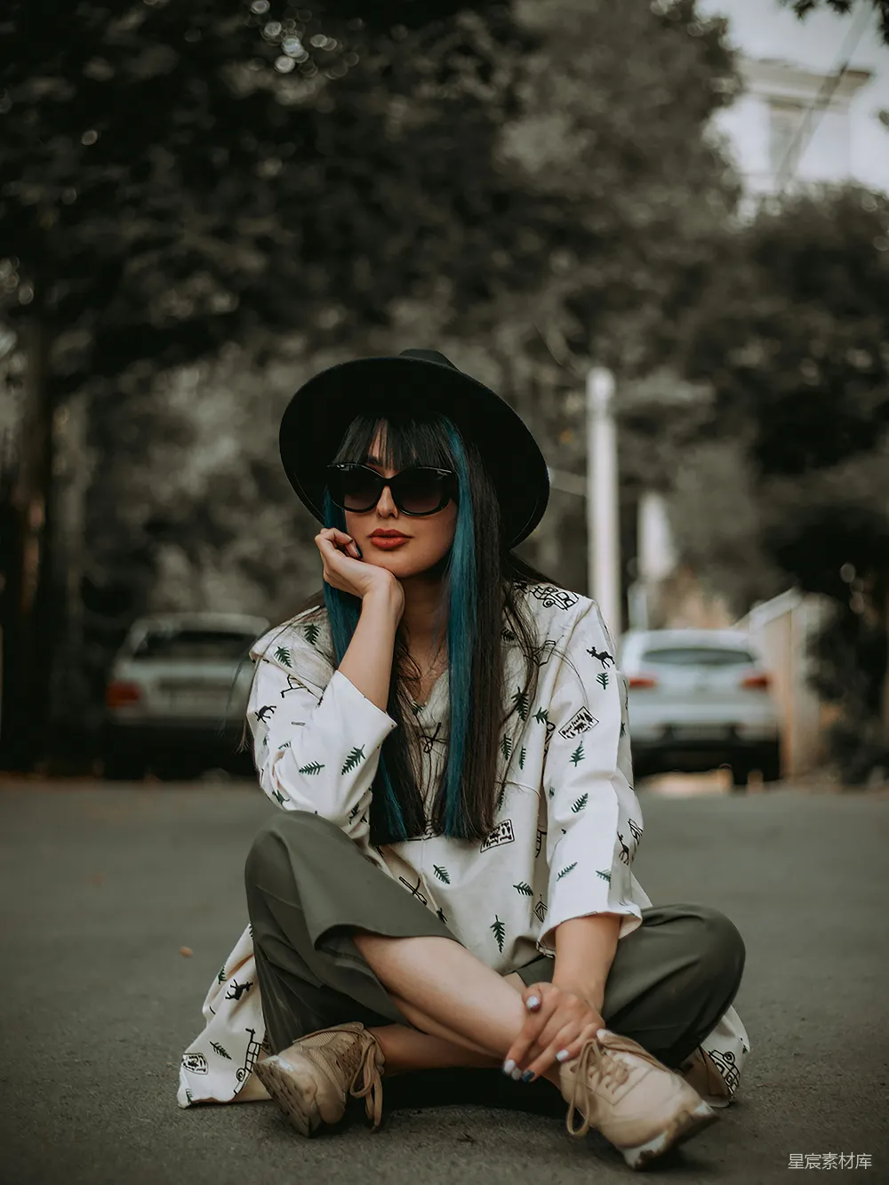 高清摄影 地上坐着一位戴着帽子和太阳镜的女人
