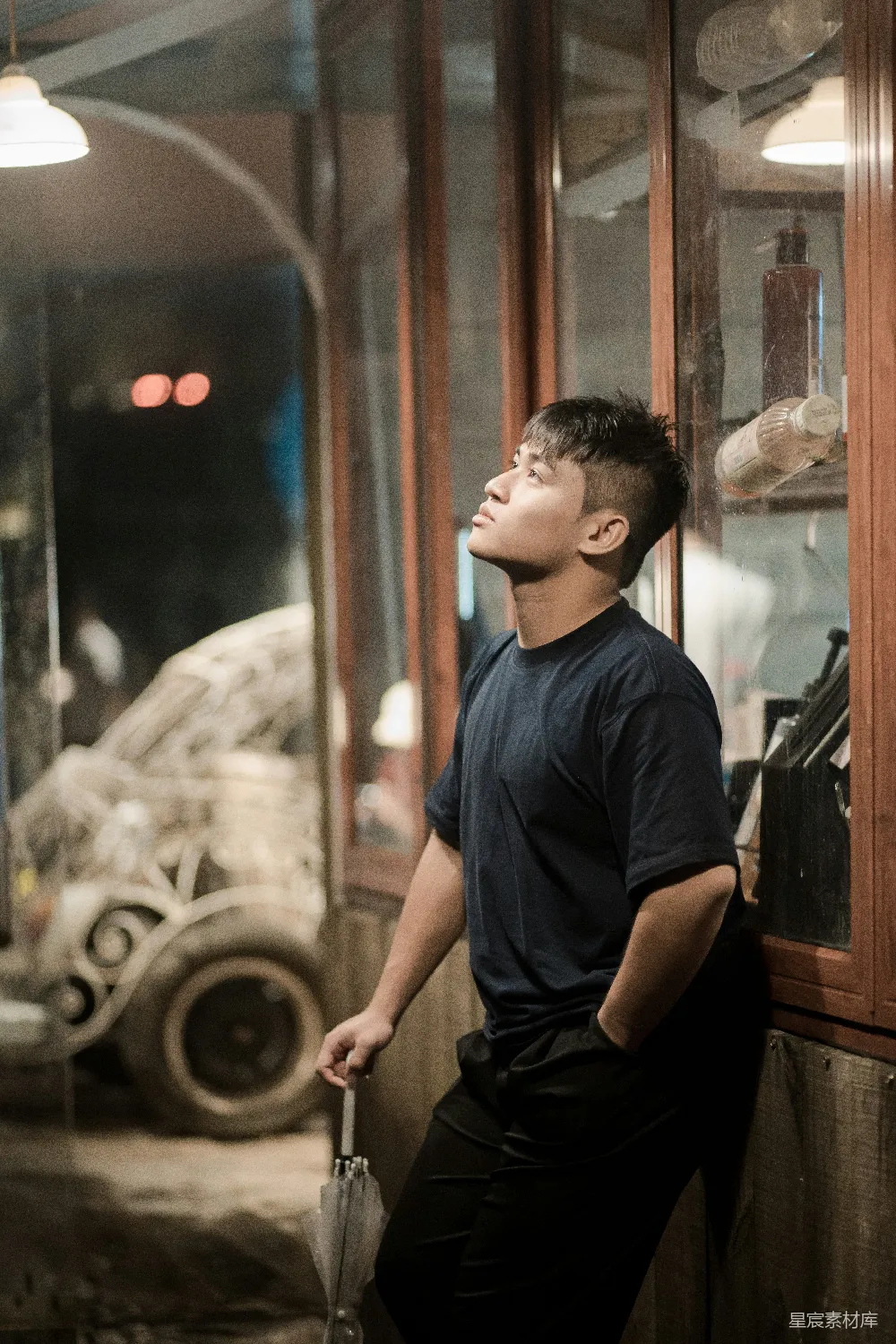 高清摄影 一个男人仰头看着上方，靠着墙壁。
